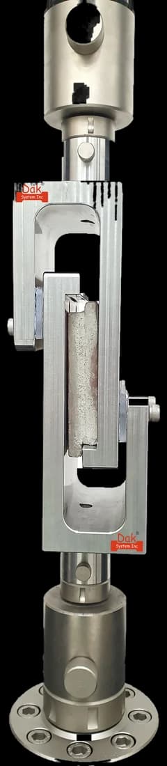 Tensile shear fixture holding a bonded specimen